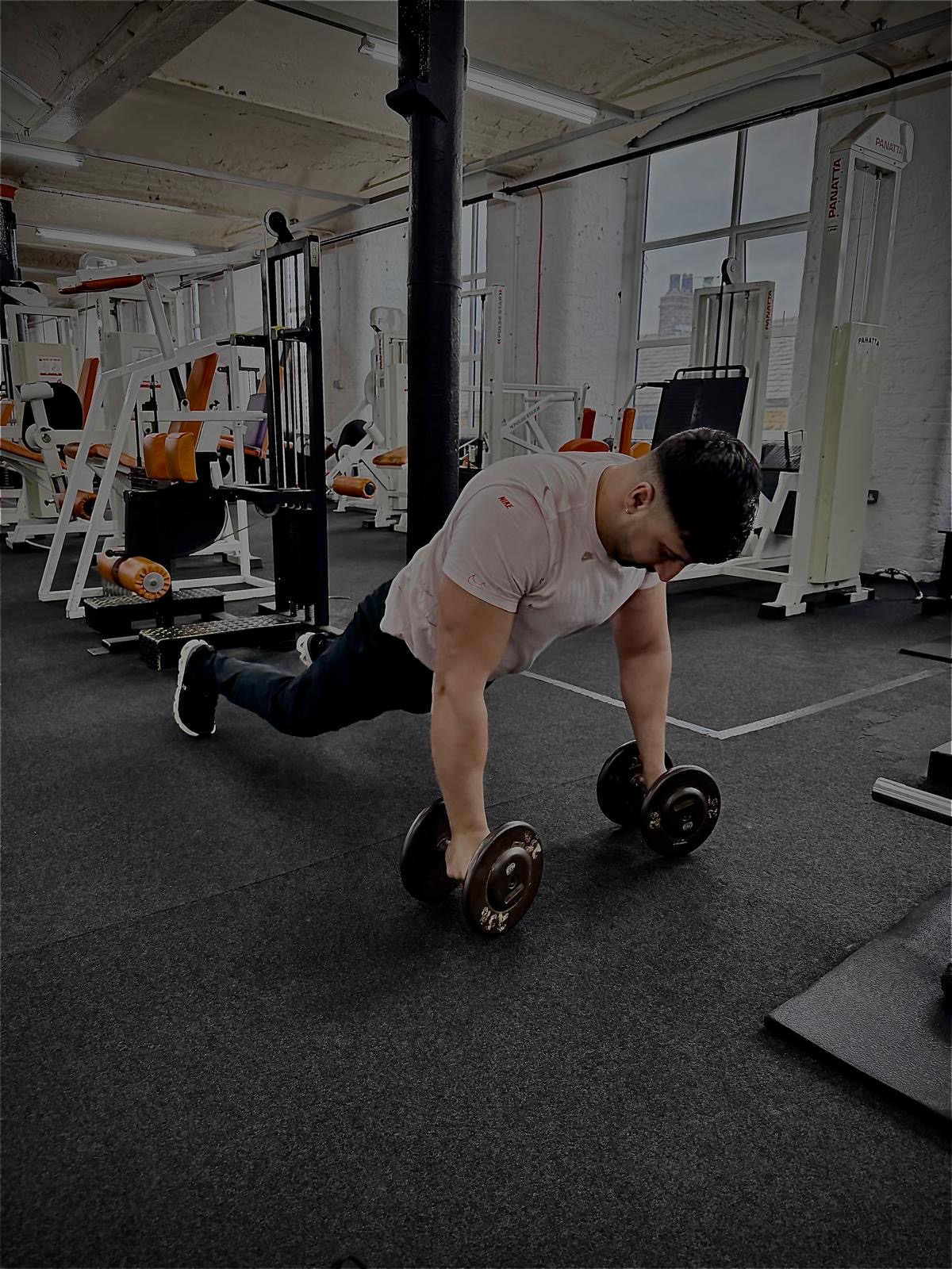 Member doing renegade rows with dumbbells