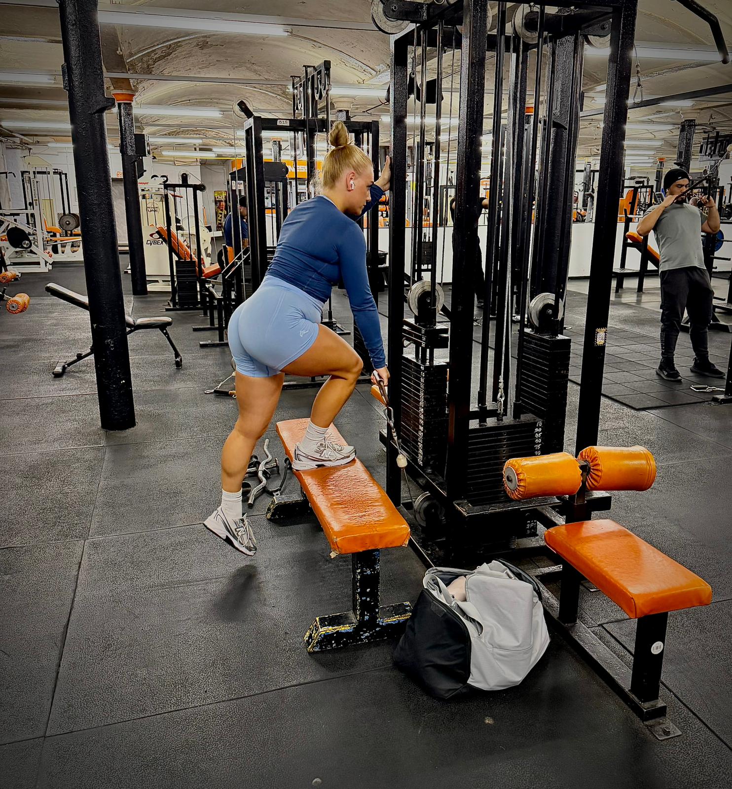 Member training with foot on the bench at the cable machine