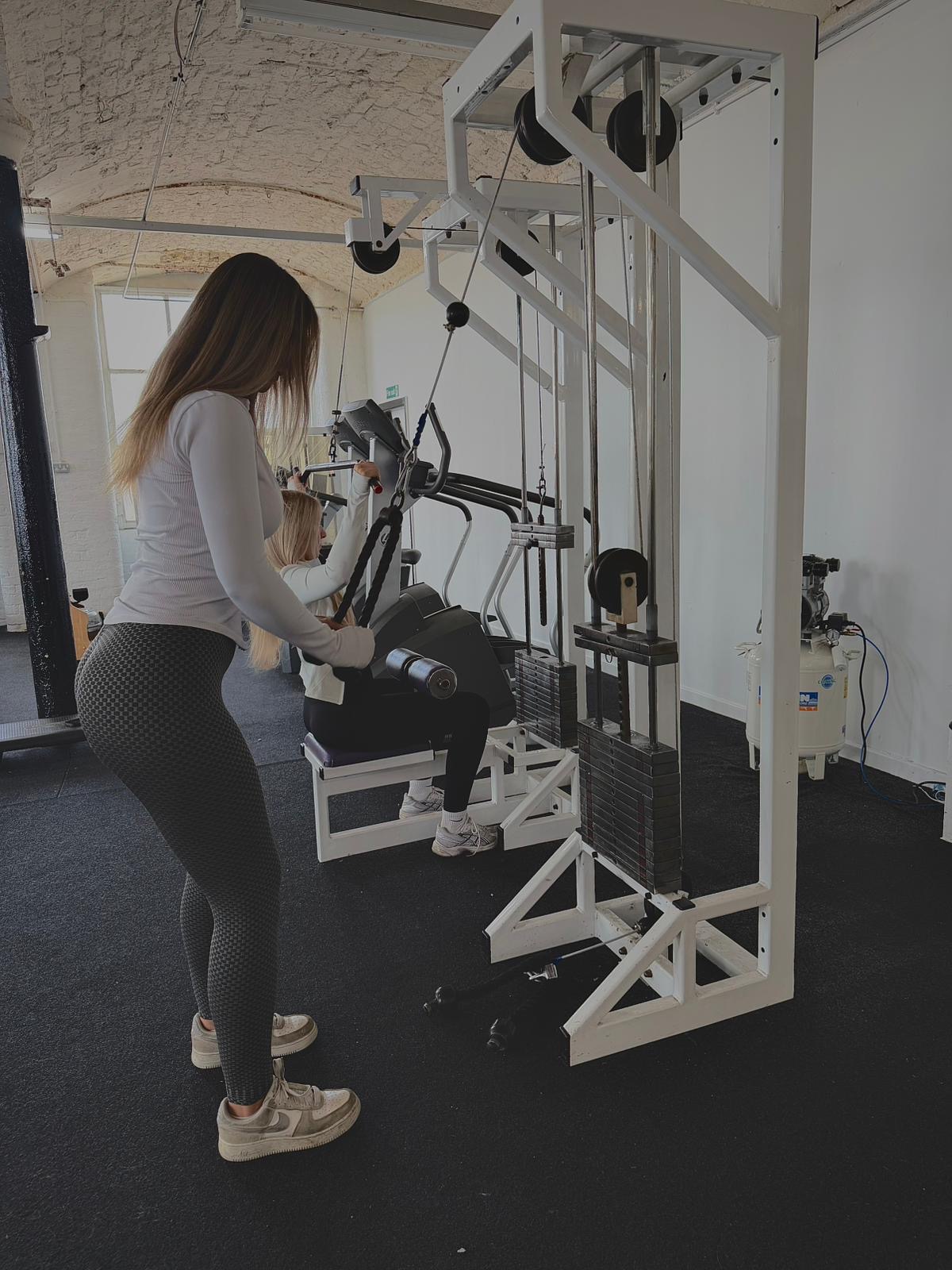 Member training on the cable machine in the women's only section